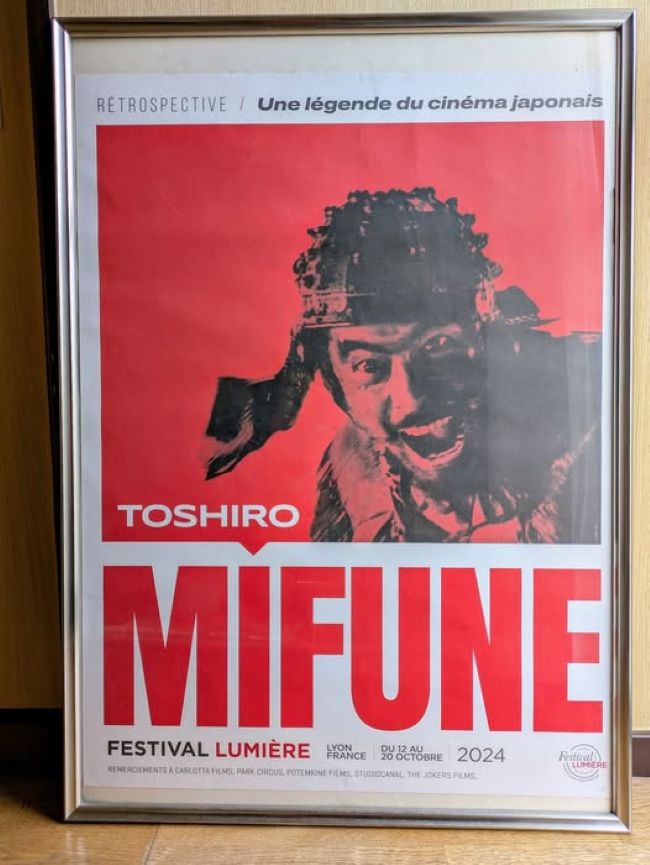 2024年リュミエール賞に輝いたイザベル・ユベールの直筆サインがあるカタログと黒澤明特集のポスター、そしてフランス語の当館チラシ